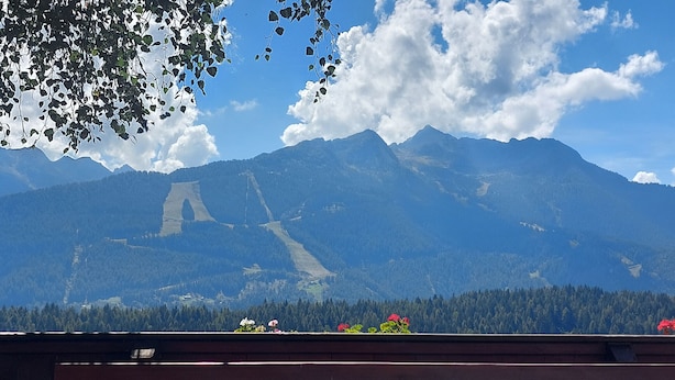Ein Esstisch mit Blick auf eine Berglandschaft.