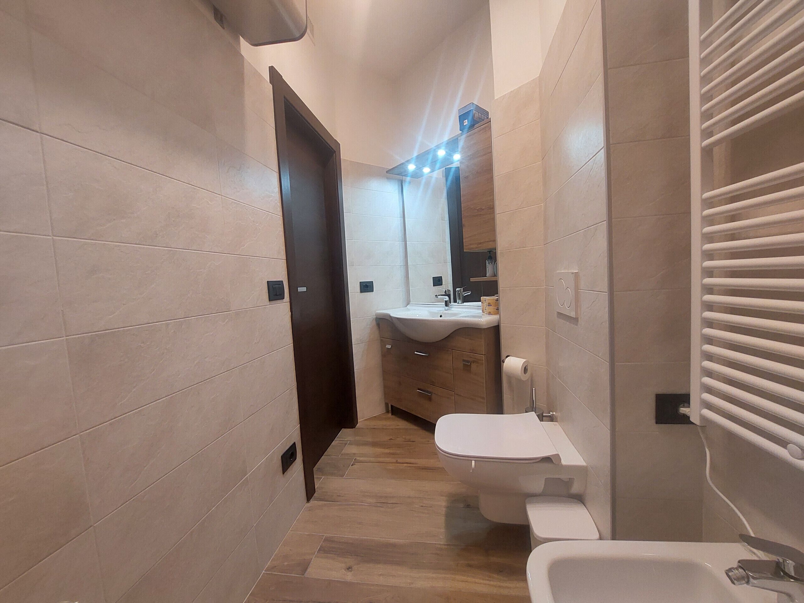 Un baño estrecho con inodoro, lavabo y bañera.