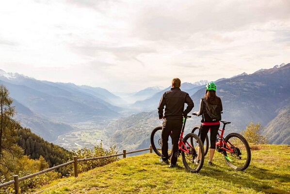 Dos personas en una colina cubierta de hierba con vista a una montaña.