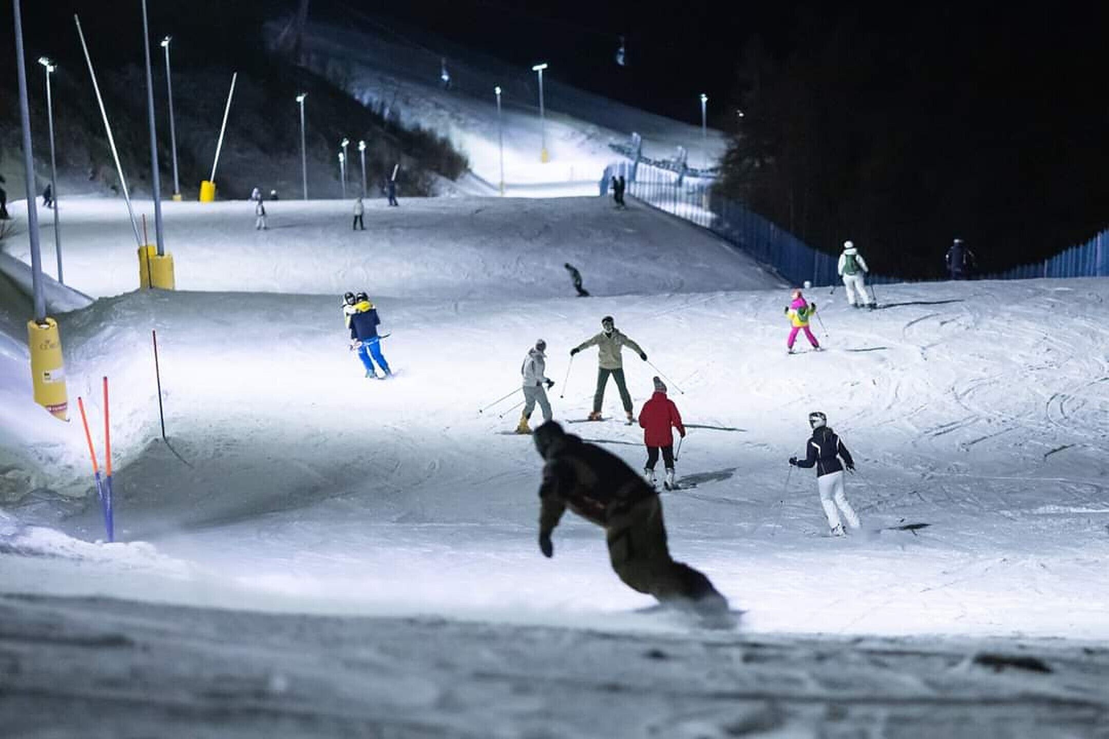Pista de esqui iluminada artificialmente à noite.