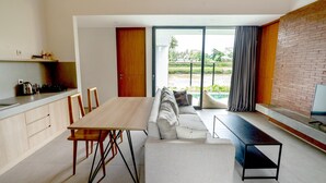 Una sala moderna con sofá, una mesa de comedor y televisor.
