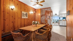 A wooden-paneled dining area with a table and chairs, a ceiling fan, and a view of the kitchen and outside. - Midtown 4 bedroom oceanfront townhome, steps from the beach (Ocean City)
