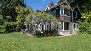 A two-story house with a garden and a pergola covered with wisteria. - Brook Farm (Ringwood)
