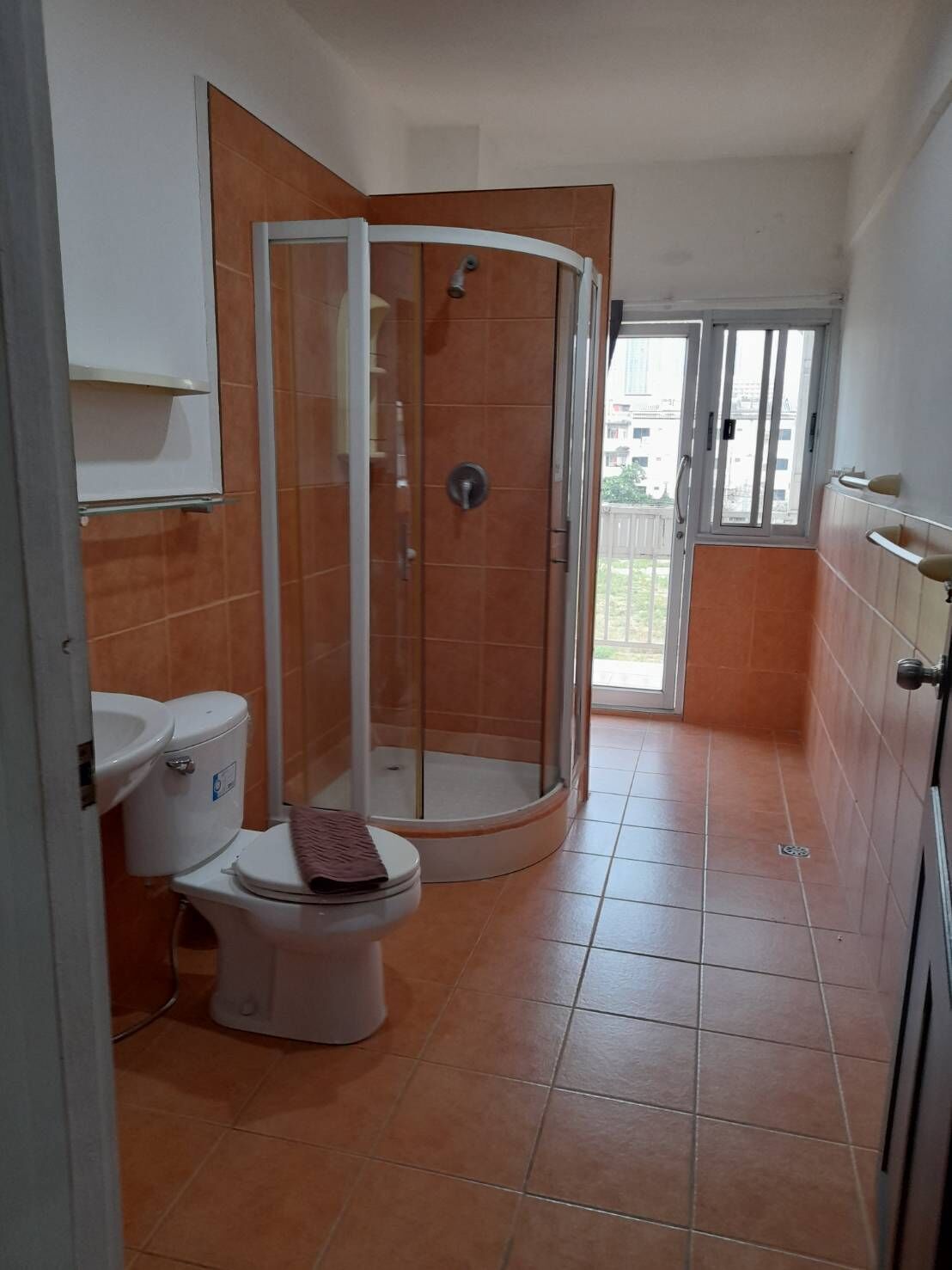 A bathroom with a shower, toilet, and sink.