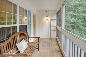 A wooden bench with a pillow, a ladder, and a view of trees through large windows. - 2 Mi to Bethany Beach! Family Home w/ Deck (Frankford)