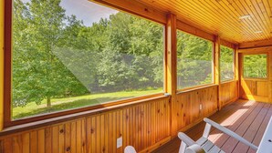 Une cabane en bois dotée de grandes fenêtres donnant sur une zone boisée.