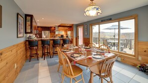A wooden interior with a dining area, kitchen, and large windows. - Spacious Finger Lakes Home w/ Mountain Views (Dryden)