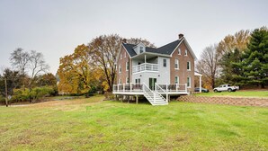A large brick house with a balcony and a staircase leading to the entrance.