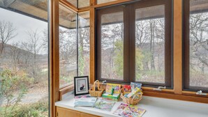 A bay window with a view of a forested area. - Historic Wisconsin Retreat on 26-acre Property! (Plain)