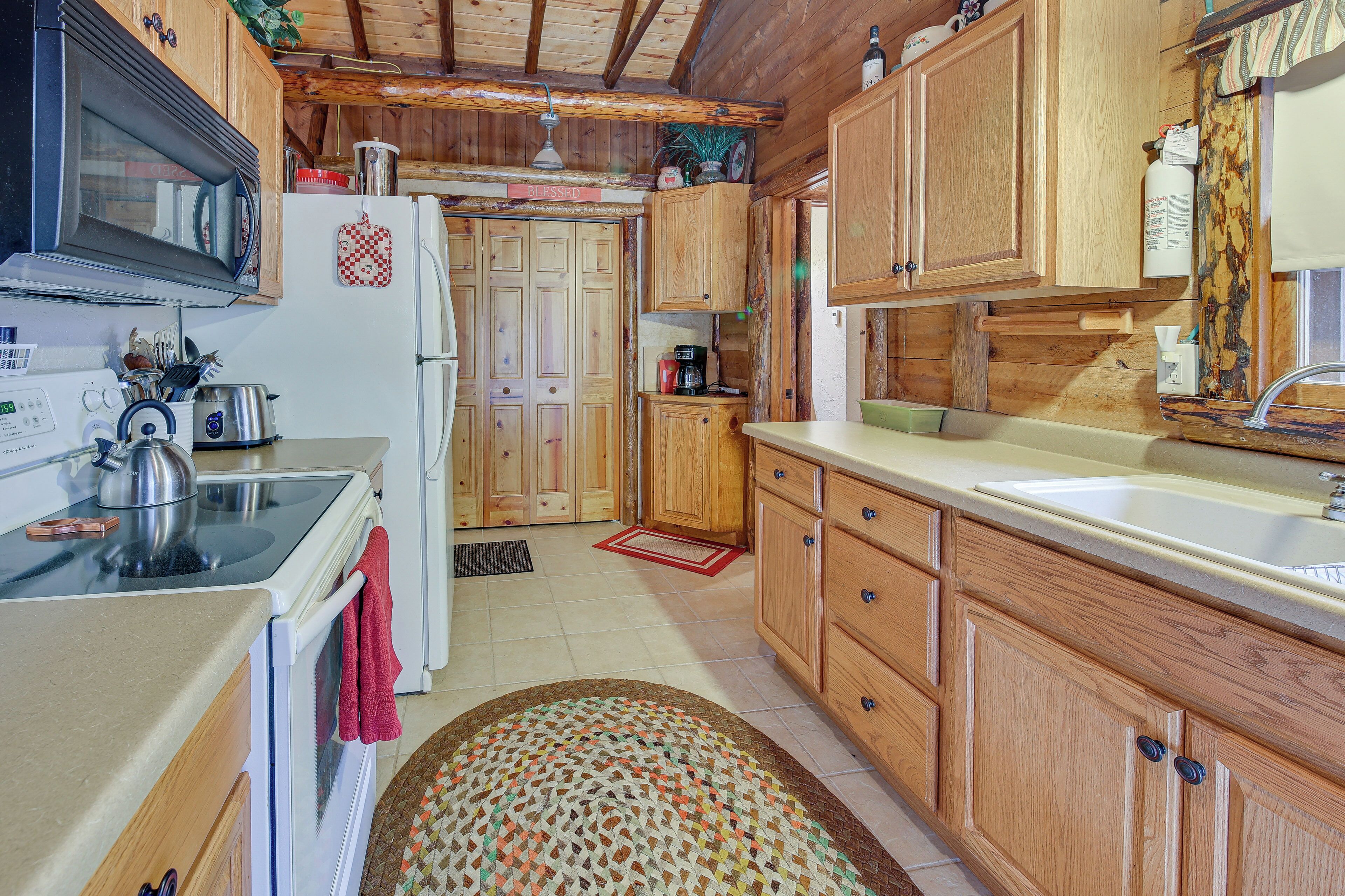 A kitchen with wooden cabinets, a white refrigerator, a stove, and a microwave.