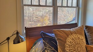 A room with a bed, a lamp, and a window with a view of trees. - Open plan, AC/FP, pool access, at South Peak, ski shuttle. P002F by LRS (Lincoln)
