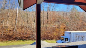 A covered outdoor area with a view of a forest and a trailer. - Open plan, AC/FP, pool access, at South Peak, ski shuttle. P002F by LRS (Lincoln)