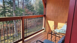 A wooden deck with a railing overlooking a forested area. - Open plan, AC/FP, pool access, at South Peak, ski shuttle. P002F by LRS (Lincoln)