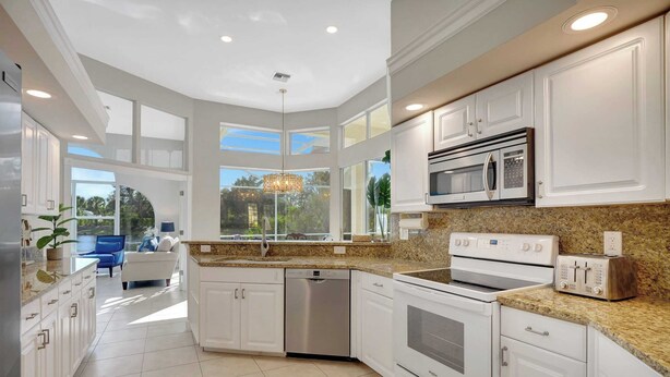 A modern kitchen with white cabinetry, a built-in microwave, a toaster, and a dishwasher.