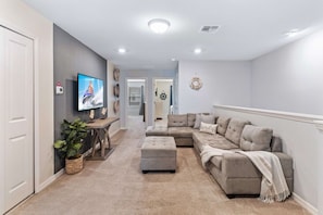 Enjoy a movie night in our stylish loft living area, complete with a plush sofa and TV. - 5BR Townhouse w/ Private Pool & Mickey-themed Room (Davenport)