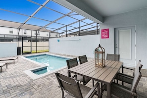 A poolside area with a table and chairs, a small lantern, and a sign indicating pool rules. - 5BR Townhouse w/ Private Pool & Mickey-themed Room (Davenport)