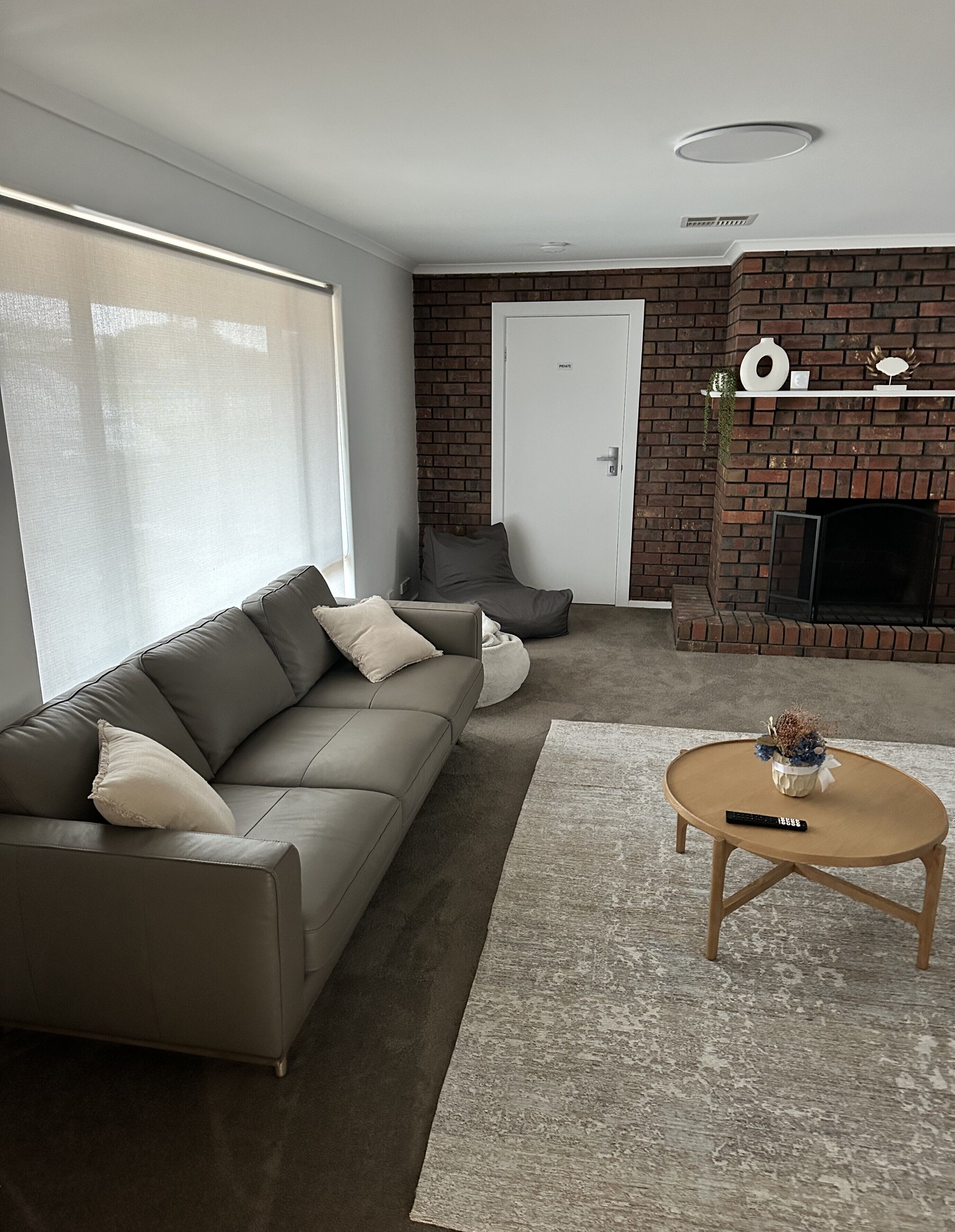 A modern living room with a sofa, a coffee table, and a fireplace.