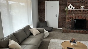 Un salon moderne avec un canapé, une table basse et une cheminée.