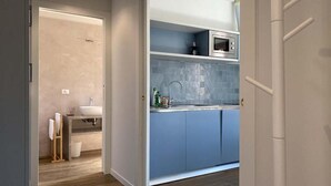 A modern kitchen with blue cabinets, a microwave, and a sink. - Ca' Magna Apartment  (Venezia)
