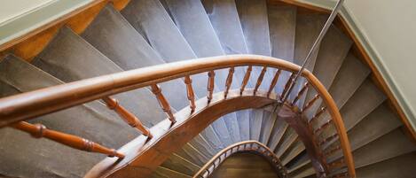 A spiral staircase with wooden handrails and steps.