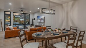 Een moderne eetruimte met een houten tafel voor vier personen, omringd door leren banken en houten stoelen.