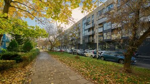 A paved walkway lined with trees and parked cars, leading to a modern building with multiple balconies. - Tastefully Arranged Studio by Renters (Wroclaw)