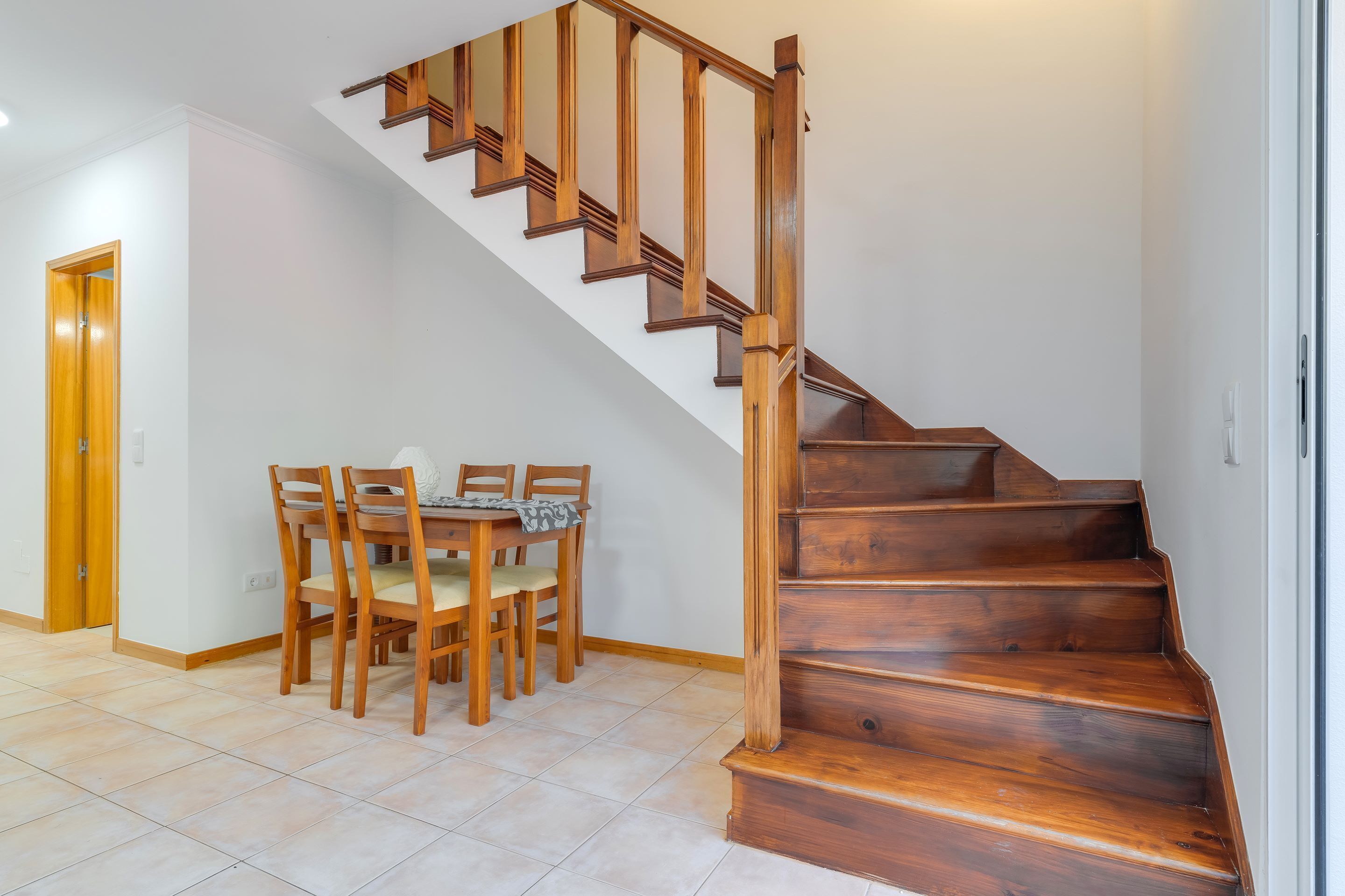 A staircase with wooden steps and a handrail, leading to an upper floor.