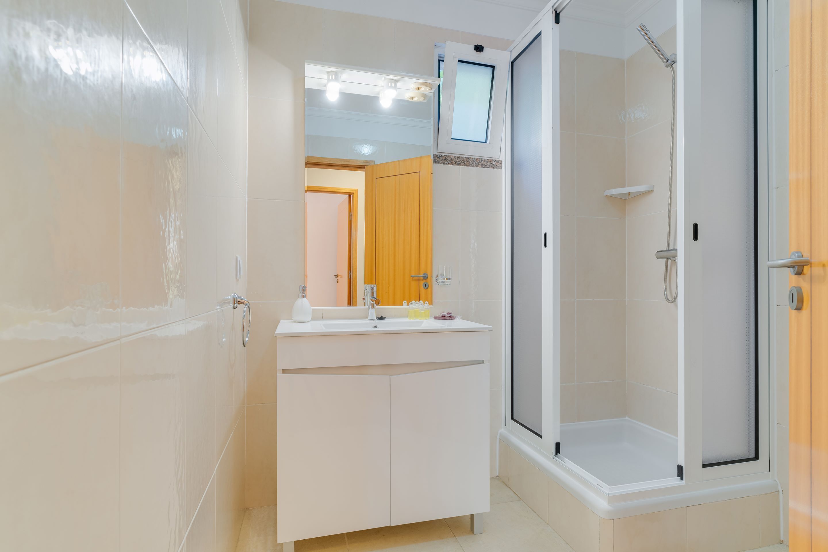 A modern bathroom with a shower, a vanity with a mirror, and a toilet.