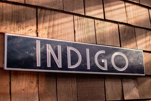 Un letrero con la palabra 'INDIGO' sobre un fondo de madera.
