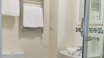 A bathroom with a toilet, a shower, and a sink.
