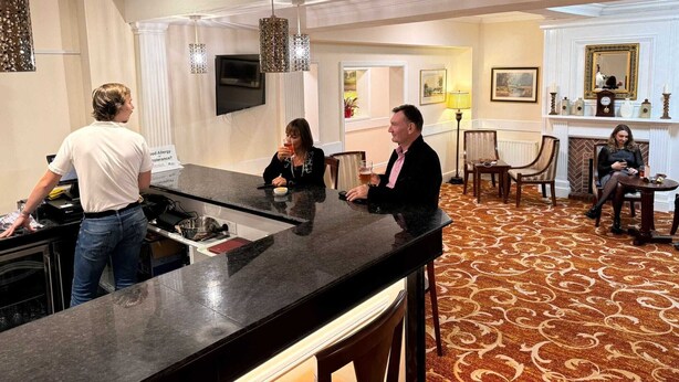 Een hotel lobby met een bar, zitgedeelte en een open haard.