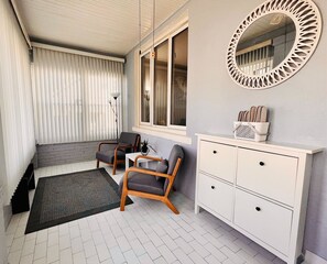 Relax in a stylish room with a seating area, dresser, and mirror.
