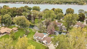 Vue aérienne d’un quartier résidentiel avec des maisons, une piscine et un lac.