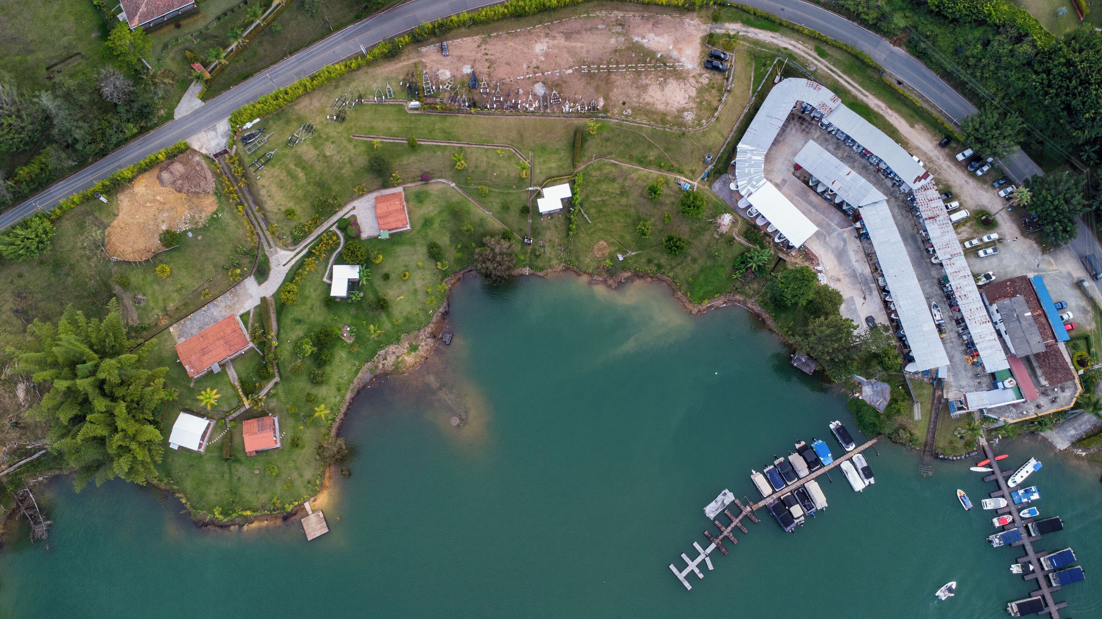 An aerial view of a coastal property with a marina, several buildings, and a large body of water.