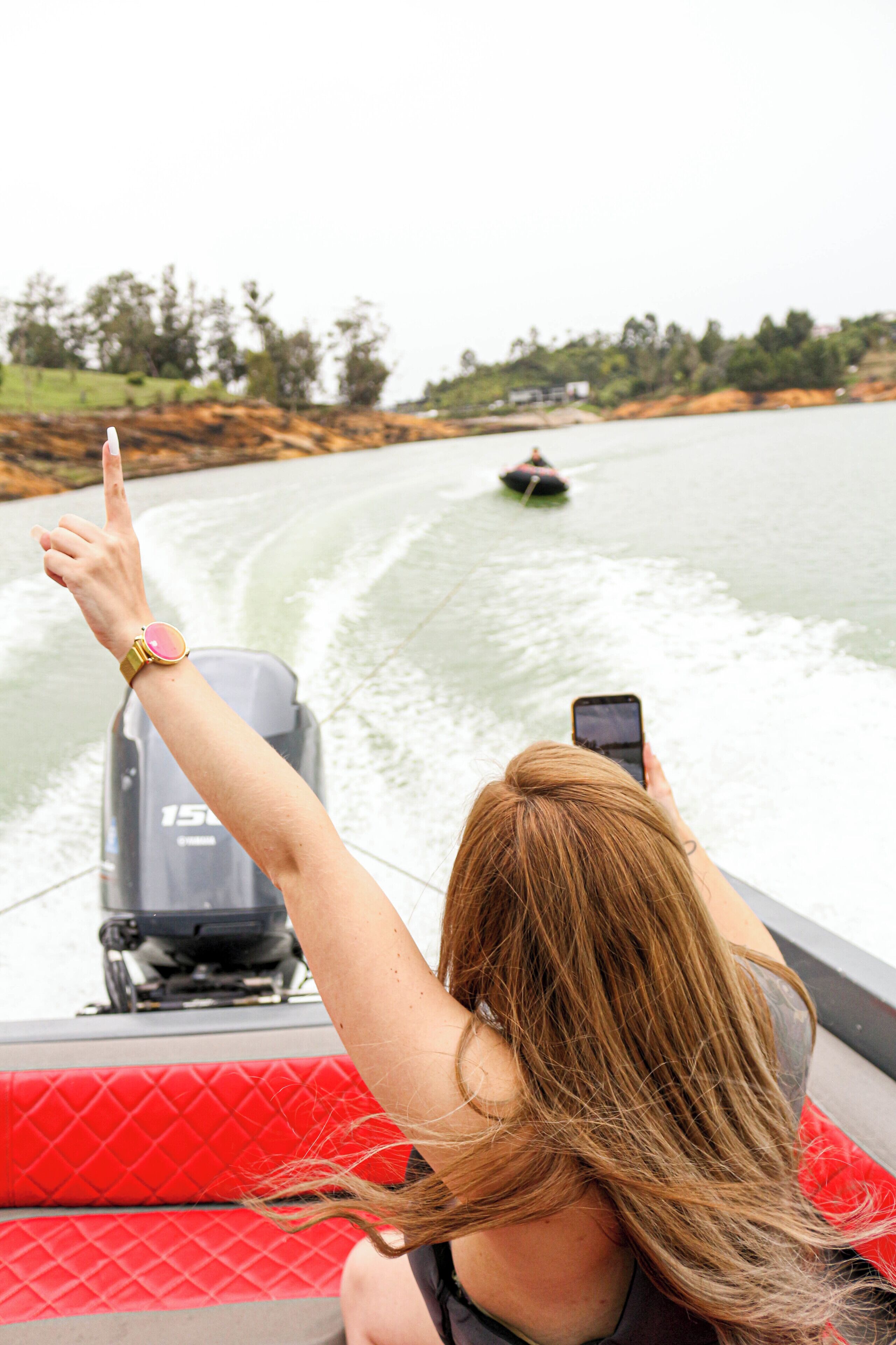 Una persona en un bote señalando y tomando una fotografía.