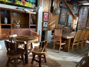 Enjoy meals in this charming dining area with a wooden table and chairs, a cabinet, and a framed picture on the wall.