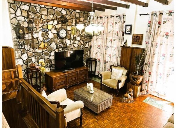 Relax in this inviting living room with a flat-screen TV, comfortable seating, and a cozy atmosphere.