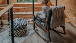 A cozy wooden interior with a large window offering a mountain view. - Secluded View! A-Frame Hot Tub and Fire Pit (Bryson City)