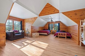 Uma cabana com quarto no mezanino, um sofá e uma mesa pequena.