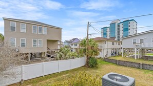 A residential area with houses, a white fence, and an air conditioning unit. - Pet Friendly 3 BR House - Latitude Adjustment (North Myrtle Beach)
