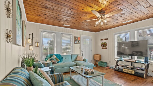 A spacious living room with a wooden ceiling, a large TV, and a comfortable seating area. - Pet Friendly 3 BR House - Latitude Adjustment (North Myrtle Beach)