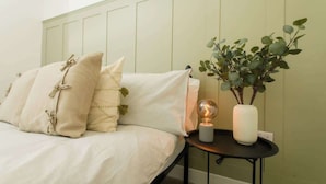 A bed with pillows, a bedside table with a lamp, and a plant. - Close to Castle | Free Wi-Fi | Close to Cathedral (Lincoln)