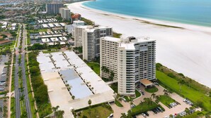Un hôtel situé sur la côte, composé de plusieurs immeubles de grande hauteur, avec un accès direct à la plage et un parking.