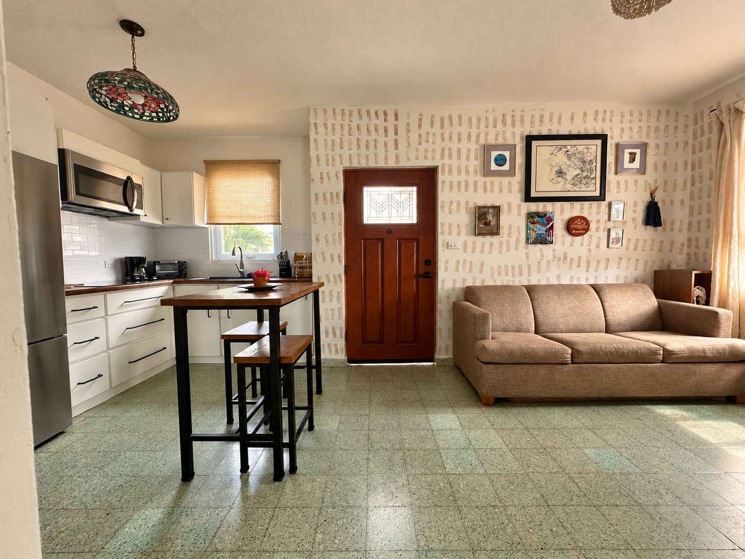 Een compact woongedeelte met een kitchenette, een eethoek en een zithoek.