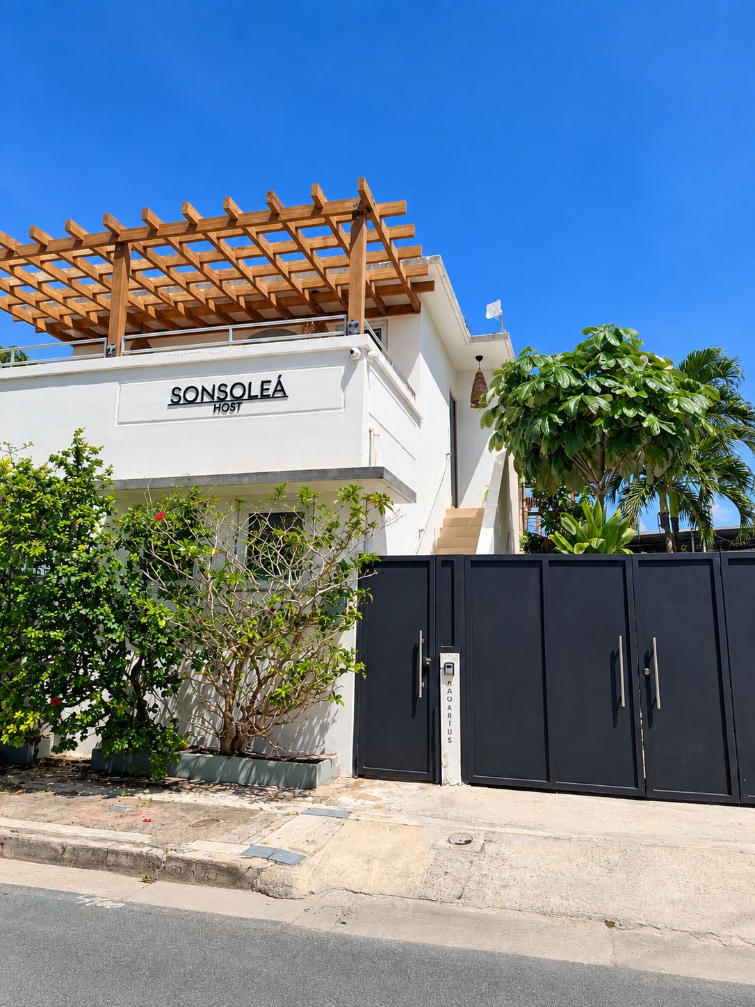 Un edificio con un letrero que dice 'SONSOLEA HOST' y una reja negra con la palabra 'AQUARIUS' escrita en ella.