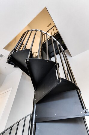 A spiral staircase with metal railings and a black handrail, leading to an upper floor. - West End 4 Bd/4Bath Walk to Bars-Close to Broadway (Nashville)
