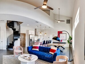 Un salon moderne avec un canapé bleu, une table basse et un escalier en colimaçon.