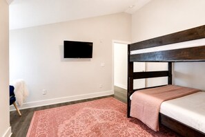 A bedroom with a bunk bed, a flat-screen TV mounted on the wall, and a patterned rug on the floor. - West End 4 Bd/4Bath Walk to Bars-Close to Broadway (Nashville)