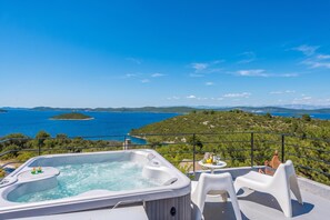 A hot tub with a table and chairs on a balcony overlooking a scenic view of a lake and hills. - Cluster Villas Vucetic (Sali)