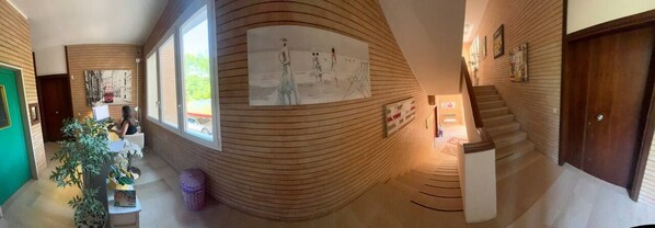 A hallway with wooden paneling, a staircase, and a door. - Casa Pineta (Grosseto)